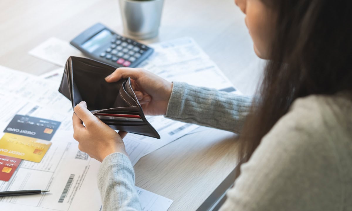 woman looking at her empty wallet